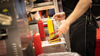Fast food restaurant cook in a kitchen assembling a hamburger.