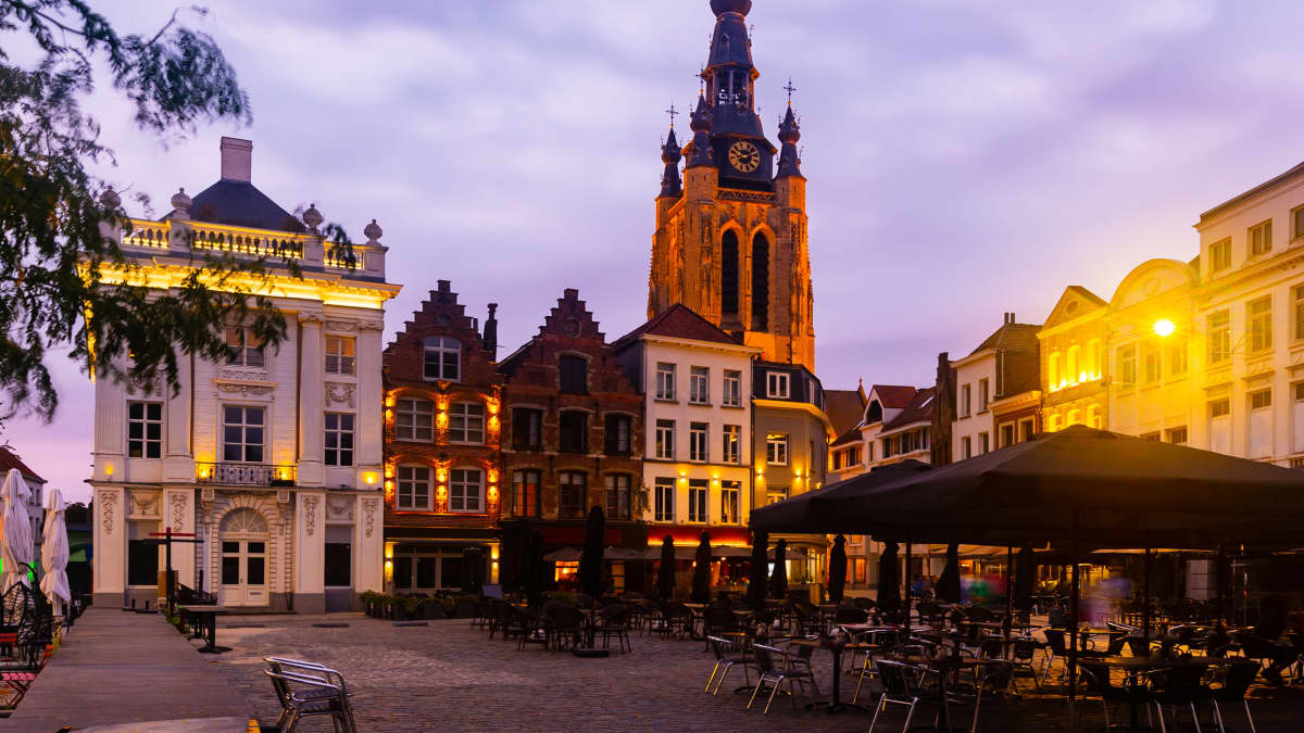 Kirkko, vanhoja taloja ja ravintolan katos Kortrijkin kaupungissa.