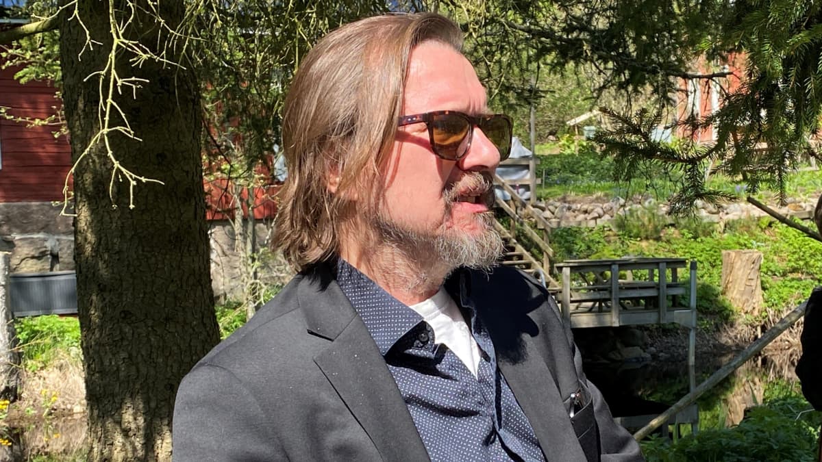 Elokuvaohjaaja Heikki Huttu-Hiltunen istuu Tammelan Portaan Nahkurinverstaan pihalla kesällä.