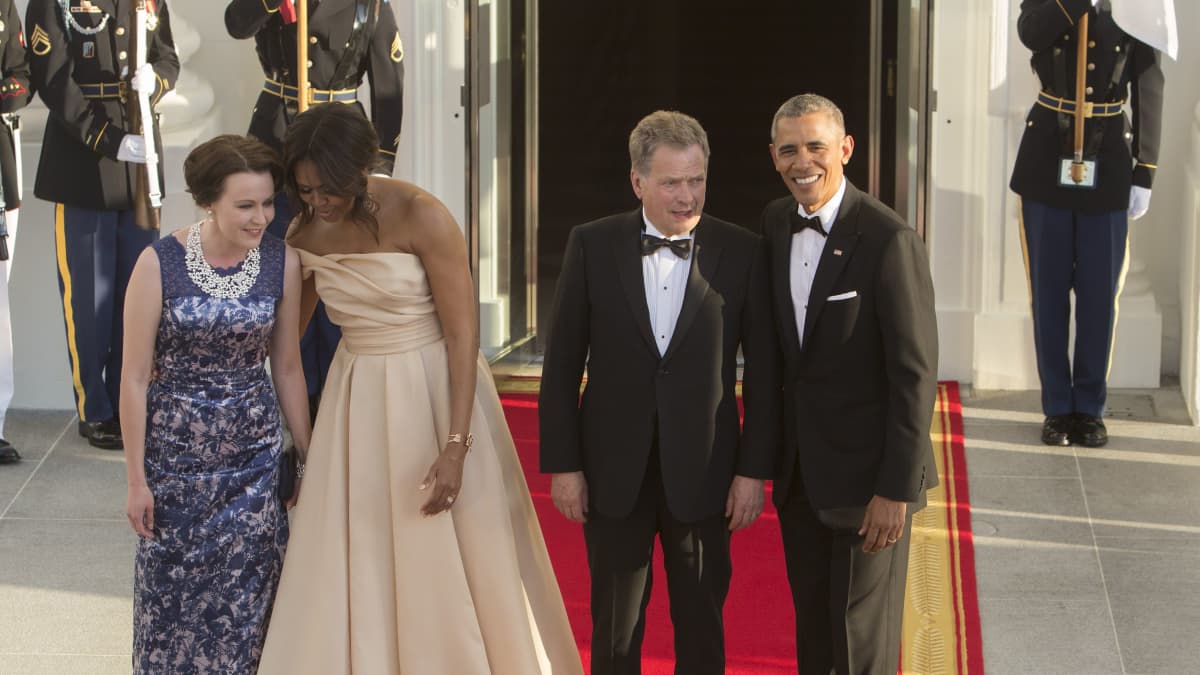 Jenni Haukio juttelee Michelle Obaman kanssa punaisella matolla Washingtonin Valkoisella talolla. Kuvassa myös presidentit Sauli Niinistö ja Barack Obama.