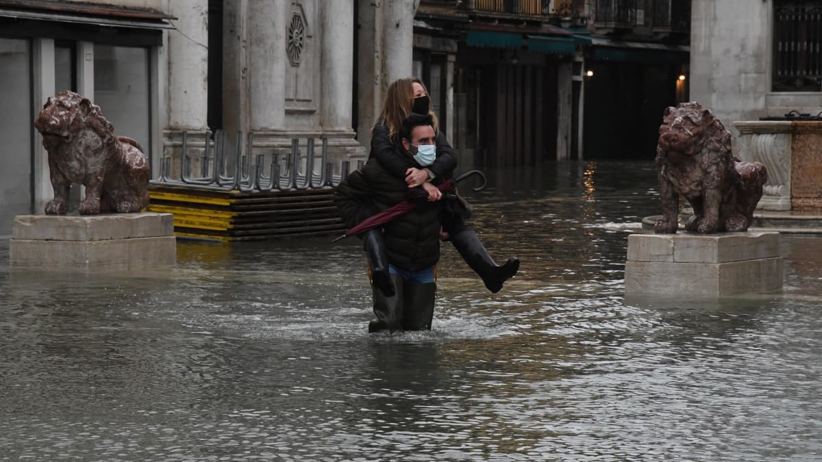 Pariskunta kahlasi Venetsiassa 8. joulukuuta 2020 korkeiden tulvavesien lomassa. 