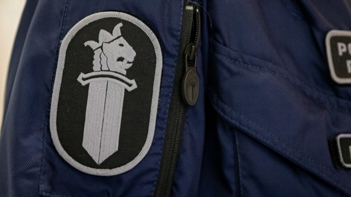 Poliisin virkamerkki työhaalarin hihassa