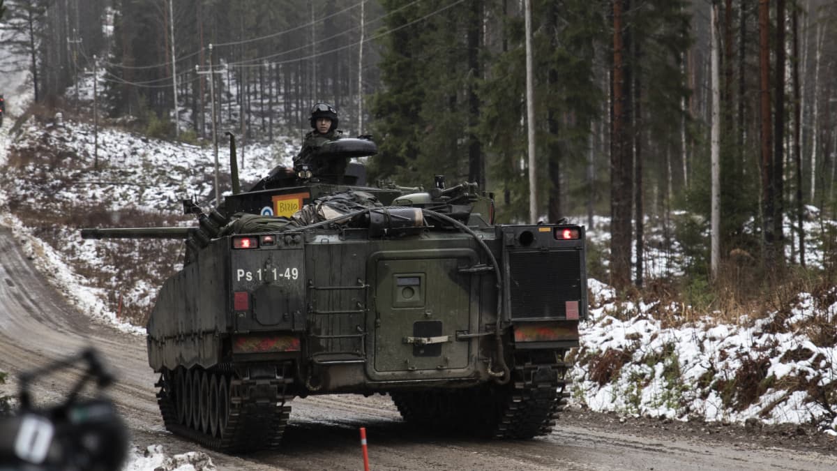 Panssarivaunu liikkuu hiekkatiellä.