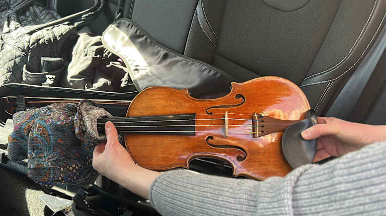 A woman holds a violin in her hands.