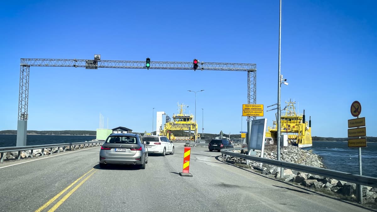Kaksi autoa ajamassa lossille. Taustalla toinenkin lossi.