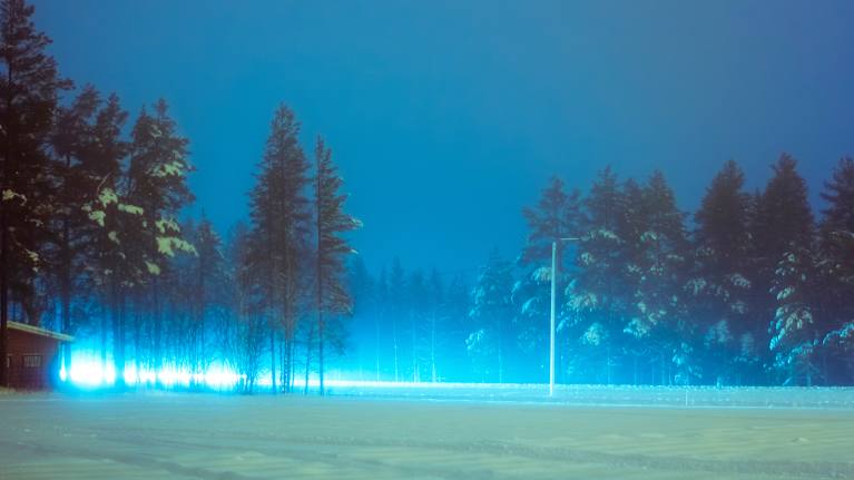 Talvisella maantiellä näkyy kirkkaan siniset valot.