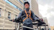 Hymyilevä Antti Sahlström poseeraa polkupyöränsä kanssa. Hänellä on päällään syyssäähän sopiva pyöräilyvarustus.