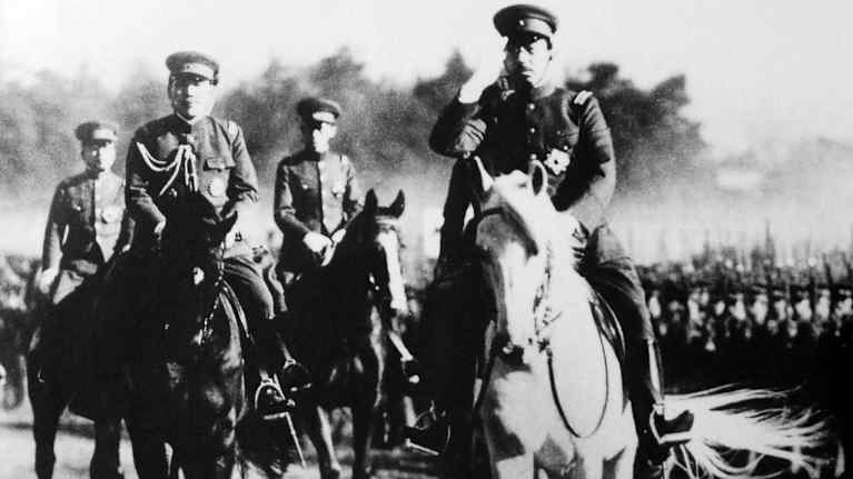 Keisari Hirohito ratsastaa joukon edessä.