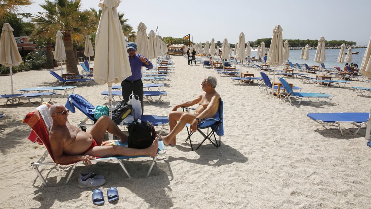 Ihmisiä auringossa kreikkalaisella rannalla.