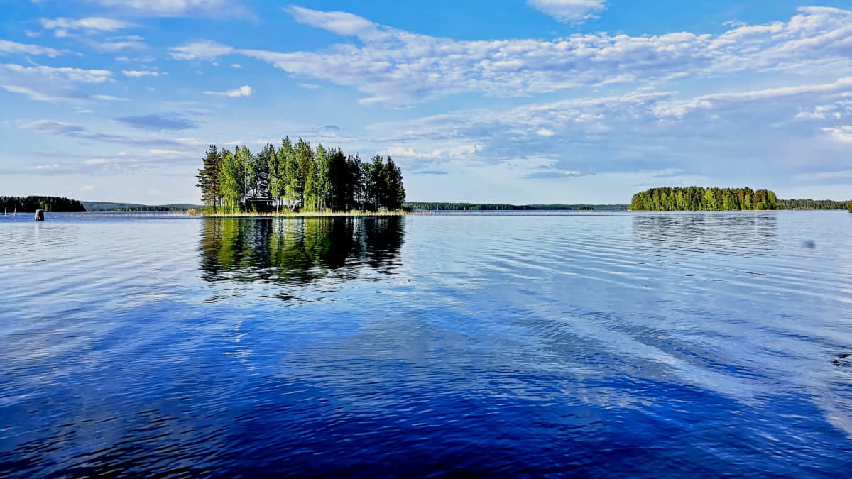 Järvimaisemaa aurinkoisena päivänä. Saaria ja aallonväreitä.