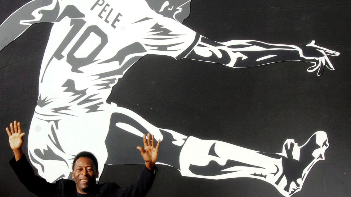 Kuollut jalkapallolegenda Pelé esiintyy hänestä tehdyn kuvataideteoksen edessä kädet ilmassa.