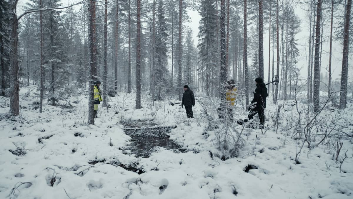 Tutkijaryhmä seisoo joukkohaudan äärellä.