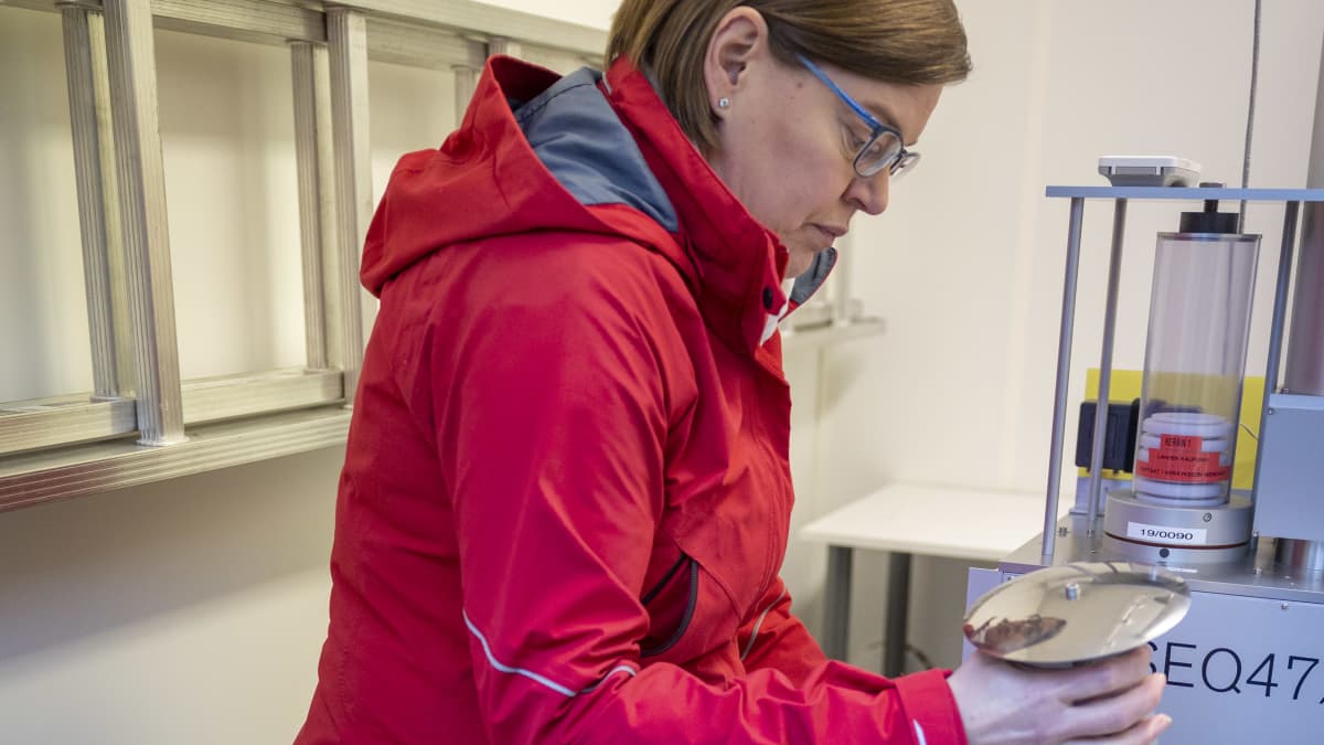 Kaarina Kähäri avaa hiukkasmittarin suodatinta.