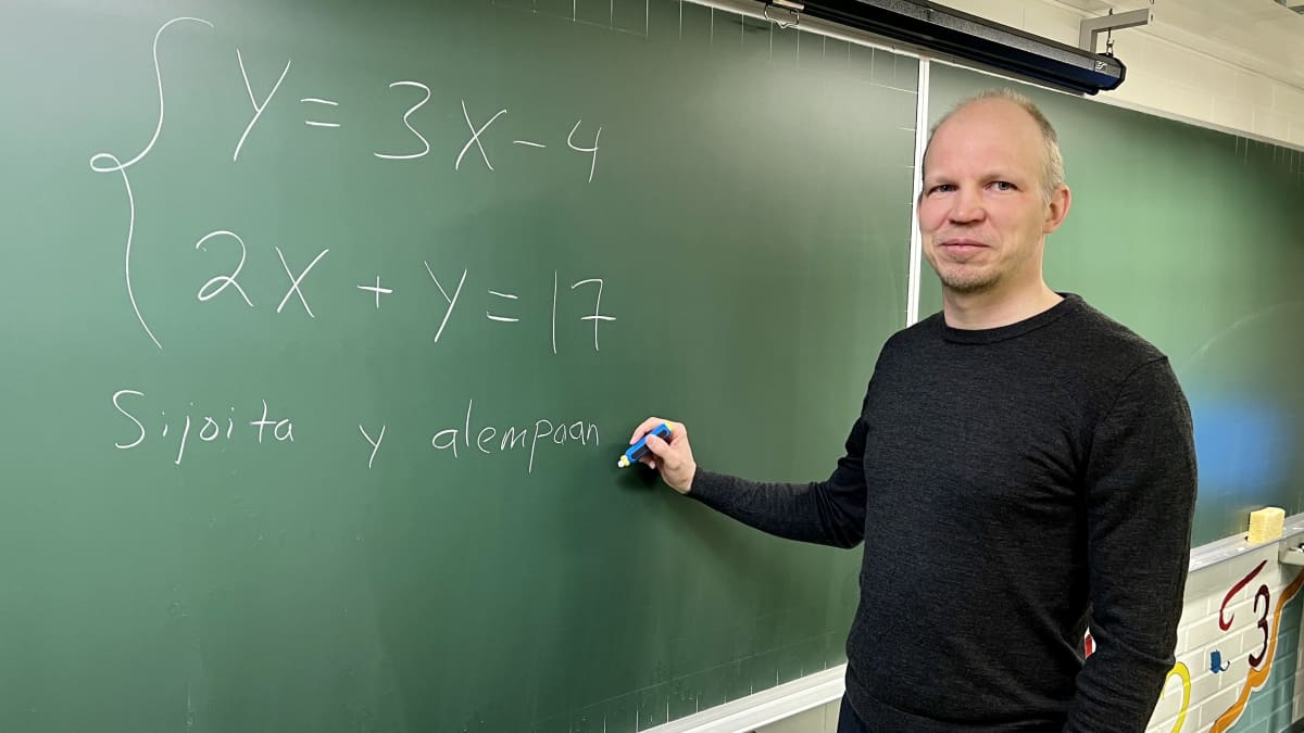 Pekka Laitinen seisoo liitutaulun edessä kirjoittamassa matemaattisia yhtälöitä.