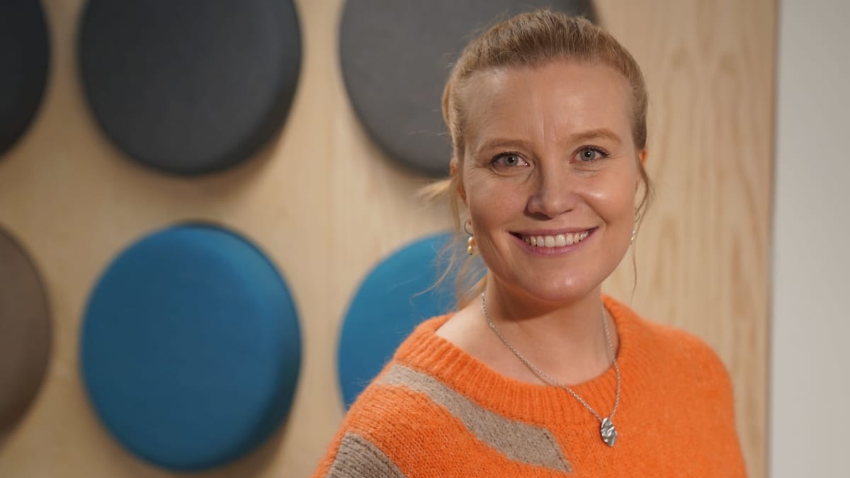 Voimistelija Maria Ovaskainen seisoo Yle:n viidennessä kerroksessa seinäkuvion edessä.