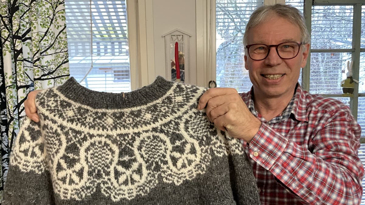 Jyrki Lipponen pitelee kutomaansa Rauma-kirjoneulepaitaa.