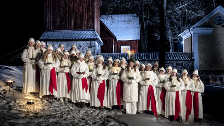 Finlands lucia 2023 Madeleine Amoroso står uppställd utomhus med sina tärnor står i ett snöigt Fagervik i Ingå. 