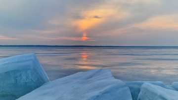 Ilta Pyhäjärvellä. Aurinko laskee, jääröykkiö ja jäätä. 