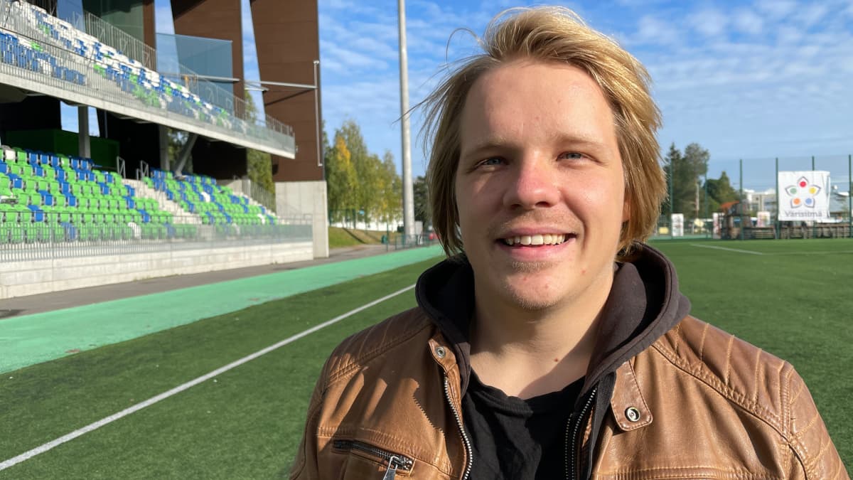 Saarni Sirkuksen yrittäjä Aarni Pahajoki seisoo Rovaniemen Keskuskentän jalkapallokentällä ja hymyilee kameralle.