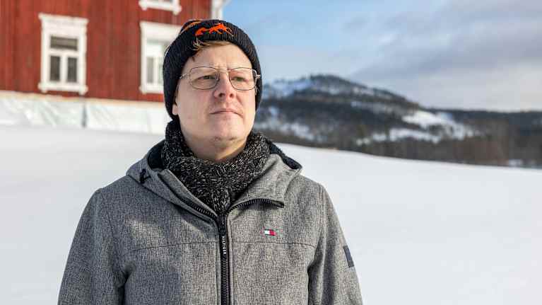 Tomi Juujärvi, taustalla punainen talo.