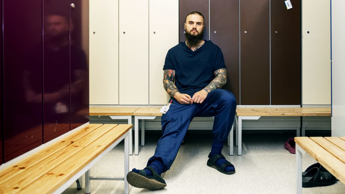 Ohjelman Areenajuliste, MOT: Sairaan pitkä hoitojono. Kuvassa sairaanhoitaja Kimmo varusteet päällään pukuhuoneessa.