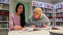 Nora Al-Sarkhi ja Viivi Laukkanen lukevat oppikirjaa Stadin ammattiopiston kirjastossa.