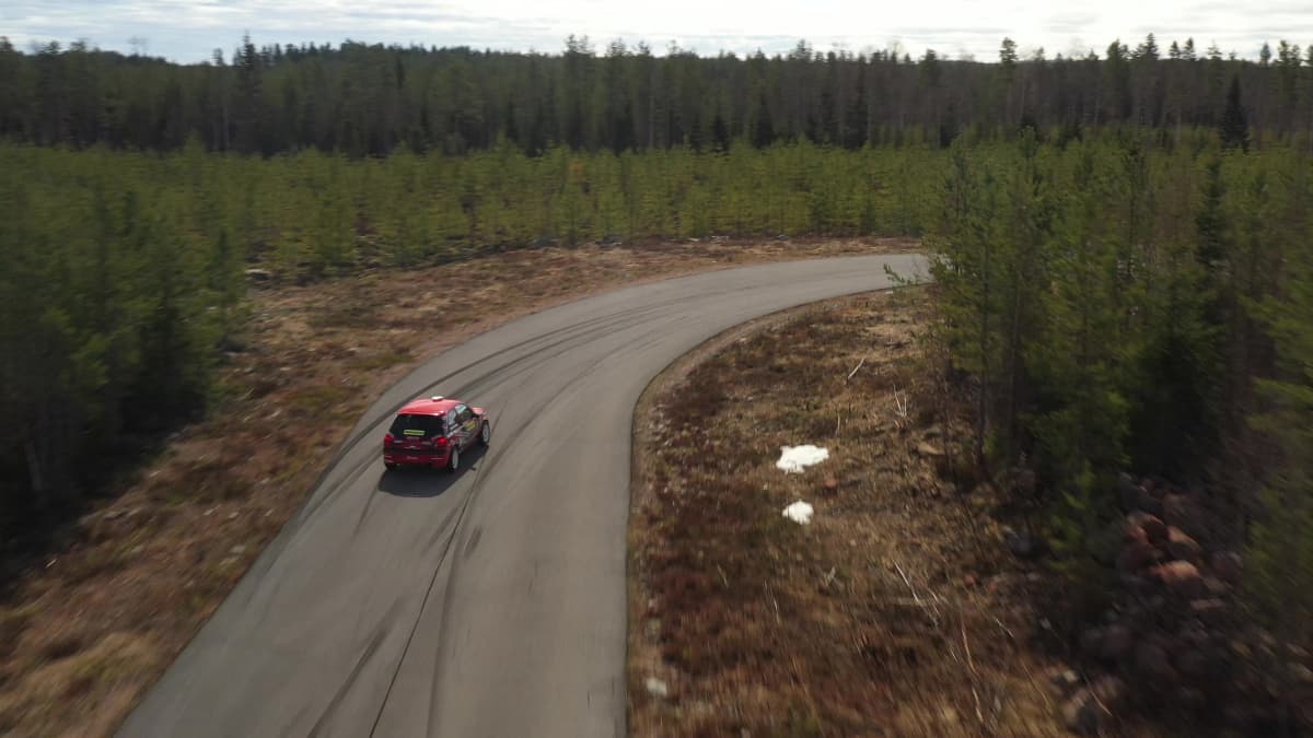 Punainen Ford Fiesta merkkinen ralli-auto ajaa mutkaan.