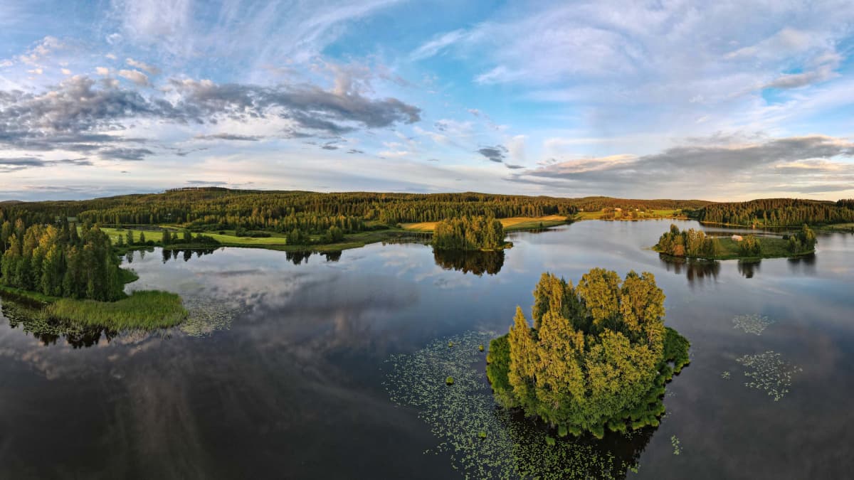 Kesäilta Jyväskylässä. Tyyni sää ja ilmakuva järvelle. Saaria ja osin selkeää säätä. 