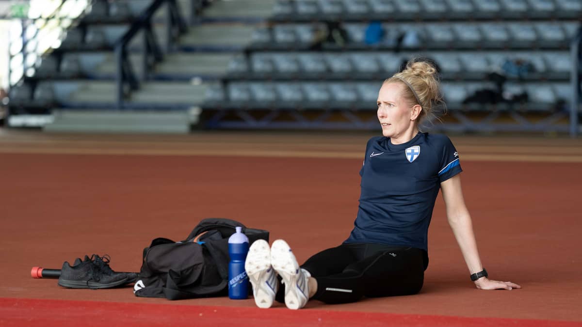 Lina Lehtovaara istuu jalkapallokentän laidalla.