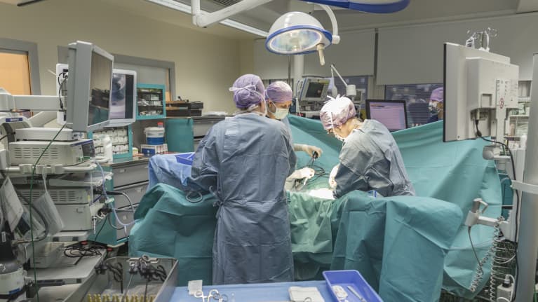 Kirurgit leikkaa potilasta leikkaussalissa.