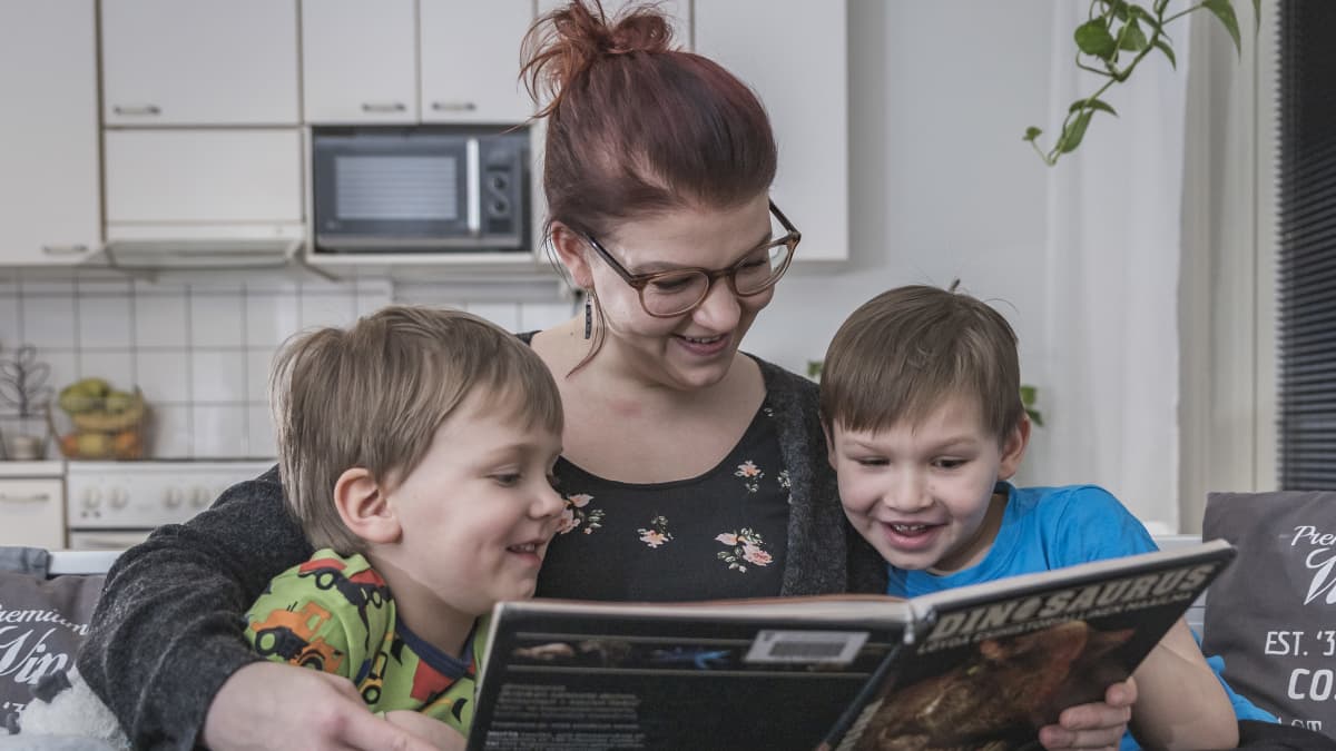 Vanhempi lukee lapsille kirjaa.