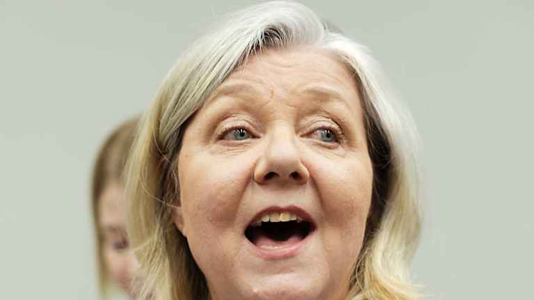 Nainen laulaa iloisesti.