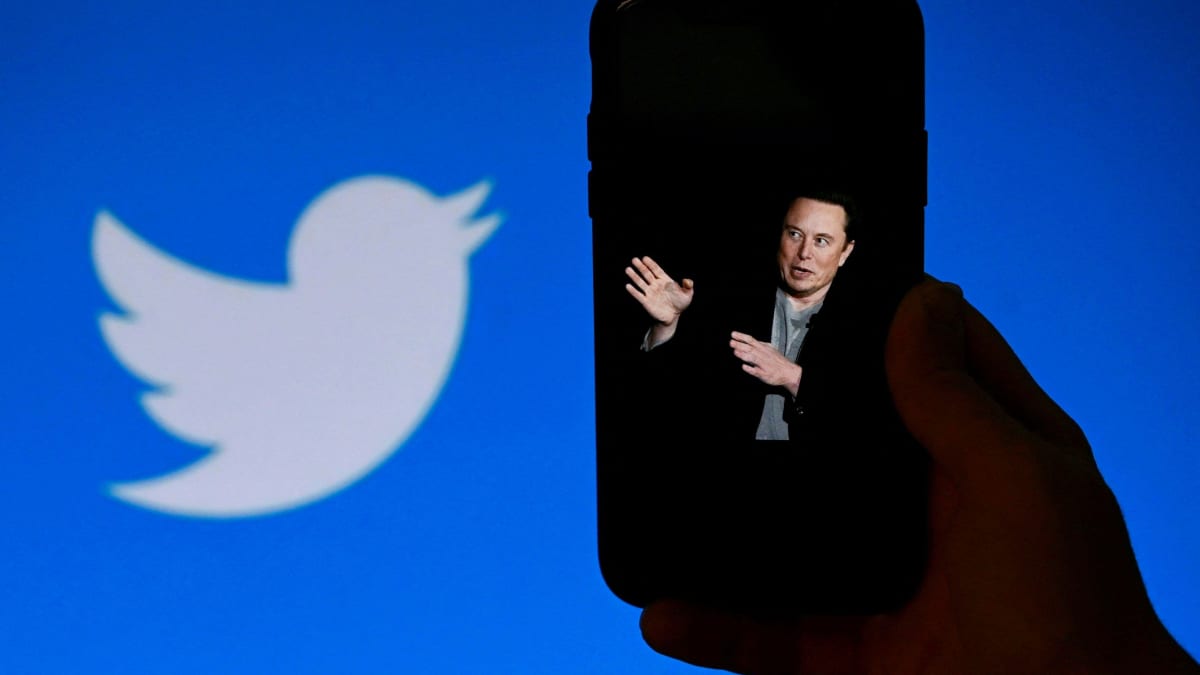 Elon Musk, taustalla Twitterin logo.