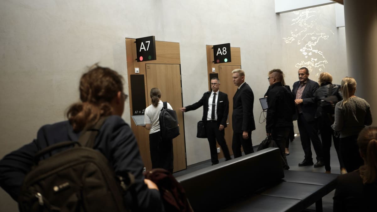 Ihmiset ovat menossa ovesta sisään Oulun käräjäoikeuden saliin.