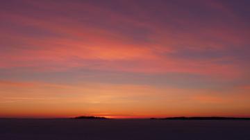 Auringonlasku Närpiössä, meren rannalla ja iltarusko värjää taivaan. 