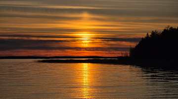 Auringonlasku järven yllä.