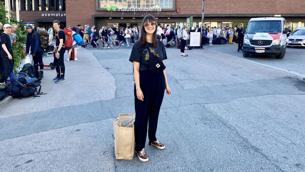 Jenna Haapaharju seisoo Tampereen rautatieaseman edessä.
