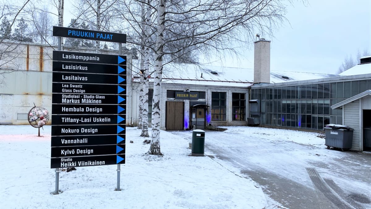 Pruukin pajat ja opastekyltti talvisessa säässä joulukuussa 2021 Nuutajärven lasikylässä.