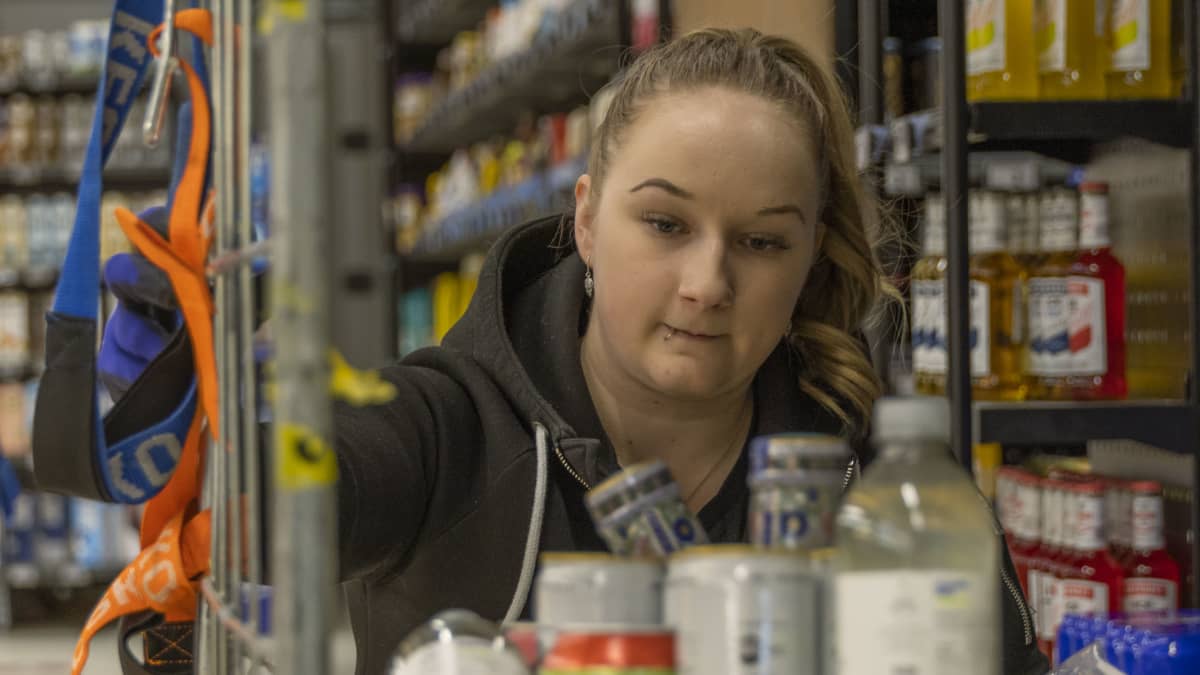 Milla Posti hyllyttää virvokejuomia Viirikankaan K-Marketissa.