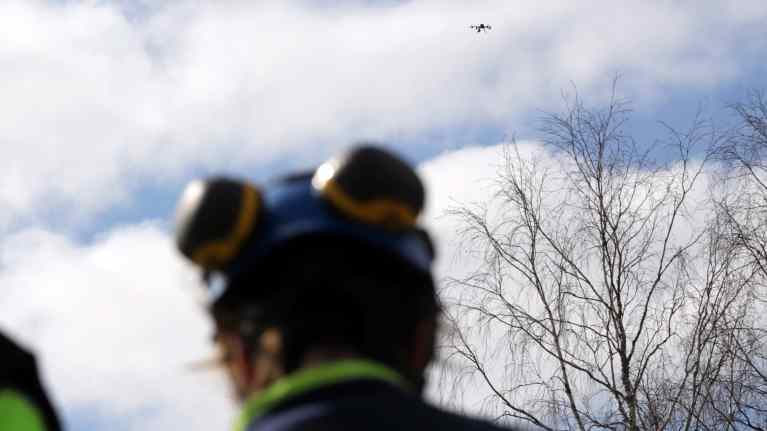Elveran työntekijä lennättää dronea sähkölinjojen tarkastuslennolla.