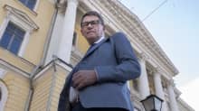 Ministeri Vanhanen poseeraa Valtionneuvoston linnan edessä.