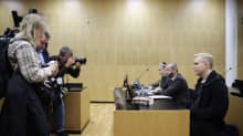 Valokuvaajat kuvaavat Aleksanteri Kivimäkeä oikeussalissa.