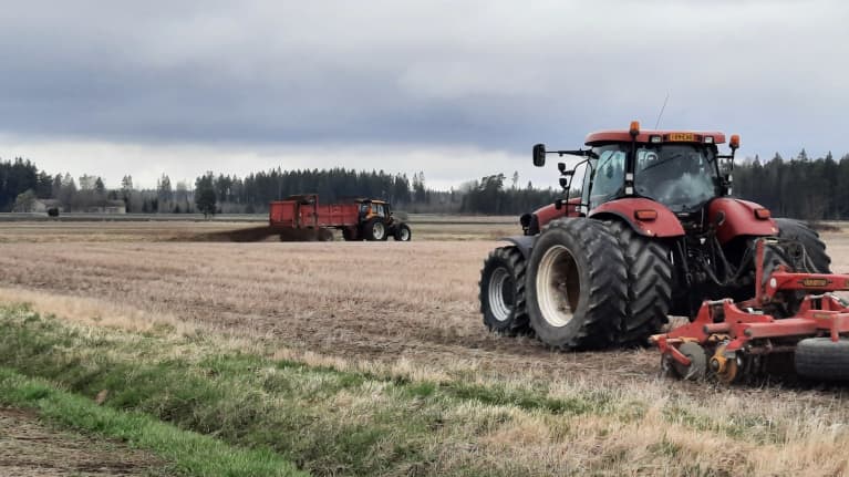 En traktor kör på en åker.