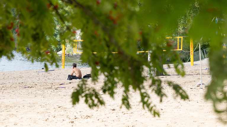 A man is sitting on the beach.