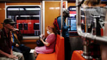 Henkilö käytti hengityssuojainta Helsingin metrossa helteisenä perjantaina kesäkuun 2020 lopulla.