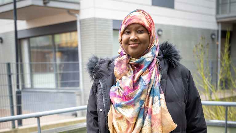 Värikkääseen huiviin pukeutunut Amal Abdi Ibrahim katsoo kameraan.