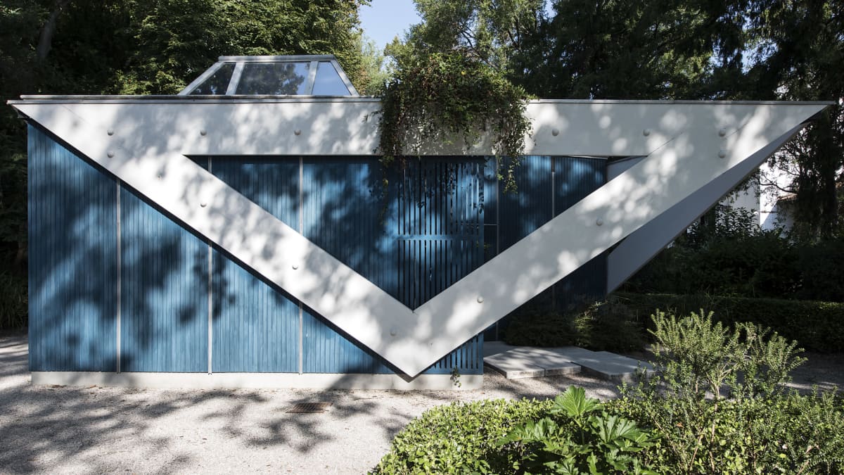 Sininen Alvar Aalto -paviljonki. Kolmiorakenne seinässä.
