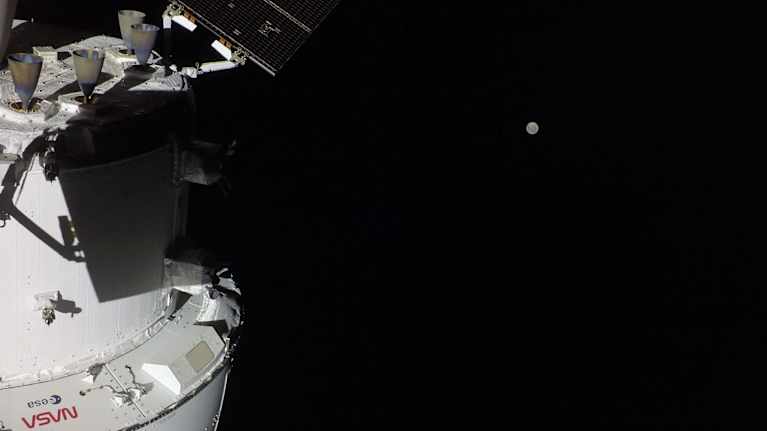 Orion space capsule in space with the moon in the background.