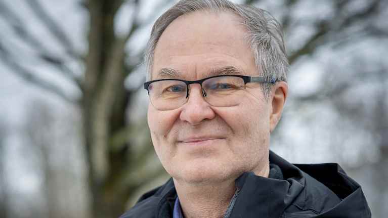 Jyri Seppälä ser mot kameran i snöigt landskap.