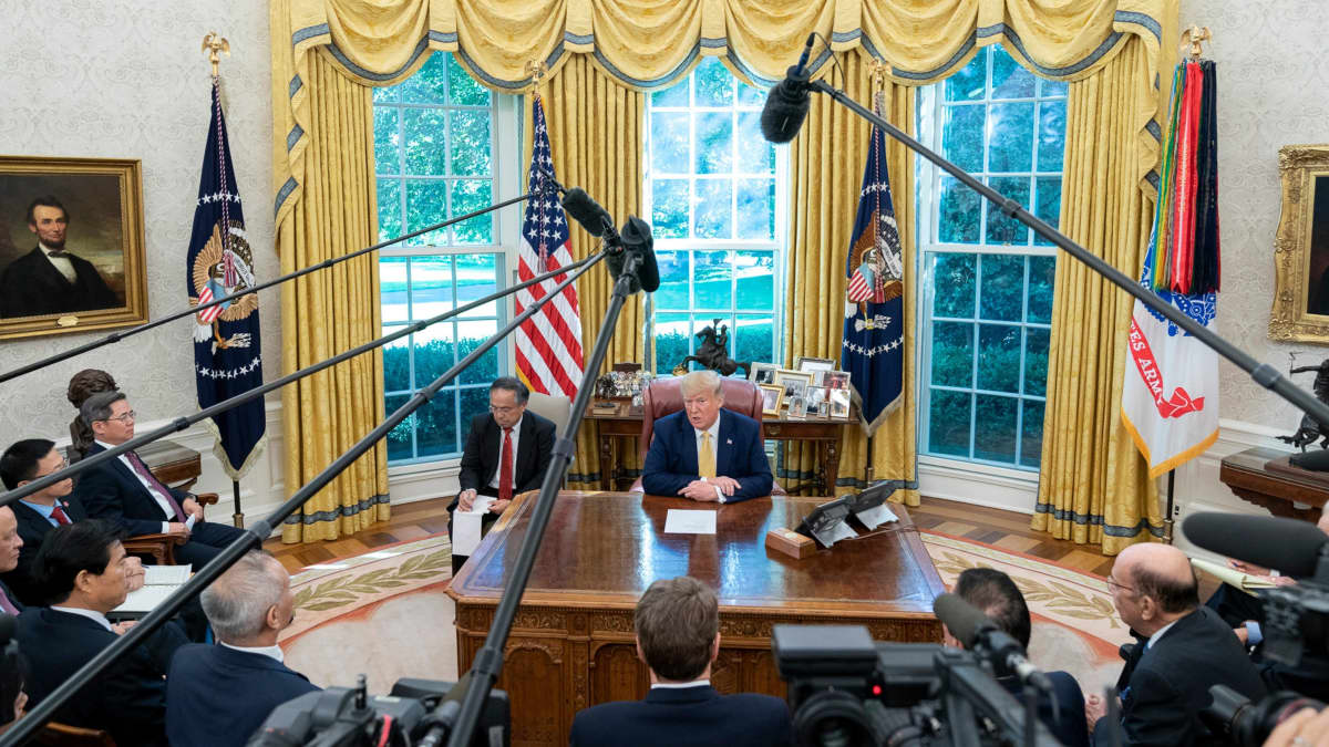 Yhdysvaltojen presidentti Donald Trump ja Kiinan varapääministeri Liu He toimittajien ympäröimänä presidentin virkahuoneessa Valkoisessa talossa.